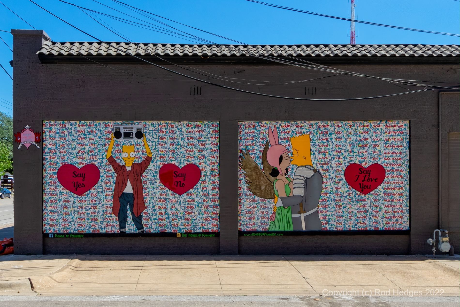 This 2-part mural depicts a "Bart Simpson" type character in two poses painted on the display windows of a former retail shop. On the left, the character, dressed in a white t-shirt, jeans, and a baggy red shirt, holds a "boombox" overhead. To either side of the character are two large red hearts; each bears a message: "say yes" and "say no" respectively. The second window mural displays the character, dressed in a knight's costume, embracing and kissing his girlfriend. The girl is wearing a green dress with accessory brown wings, and a pink hat with rabbit ears. A symbolic crest has been placed to the upper left of this mural, on the corner of the building; it identifies the artist's guild "Pannek".